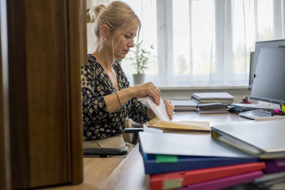 Specjalistka od rozrachunków przygotowuje pismo ze zgłoszeniem wierzytelności i kopie faktur