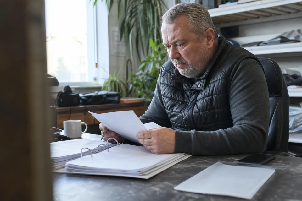 Właściciel firmy z niezapłaconą fakturą i segregatorem